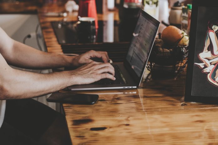 Person arbejder med computer på skrivebord