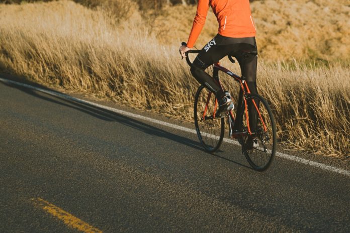 Person cykler op ad bakke på racercykel